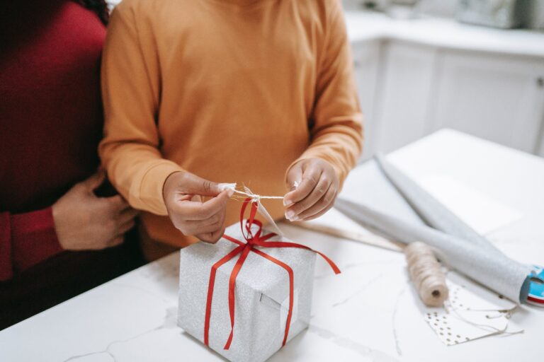 ethnic mother and daughter preparing christmas present