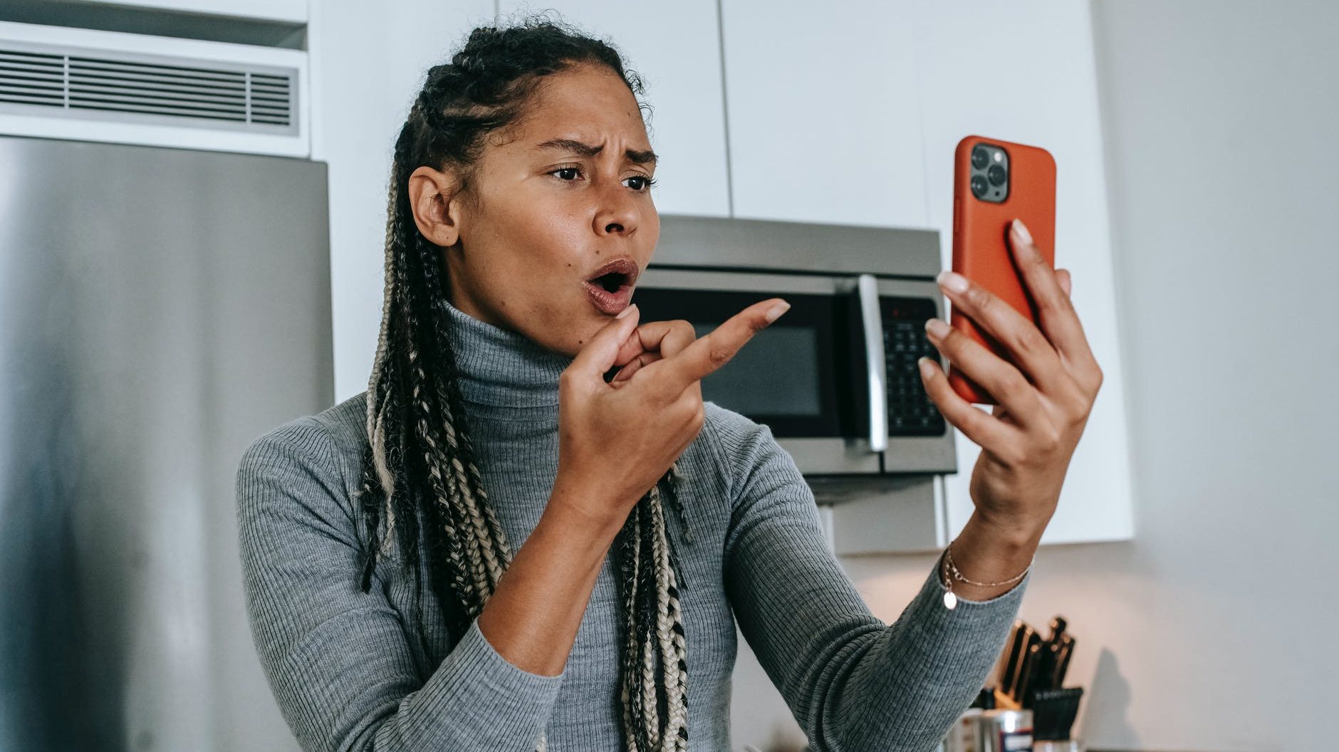 expressive young black lady arguing during video conversation on smartphone