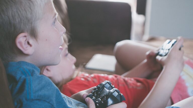 two boy and girl holding game controllers