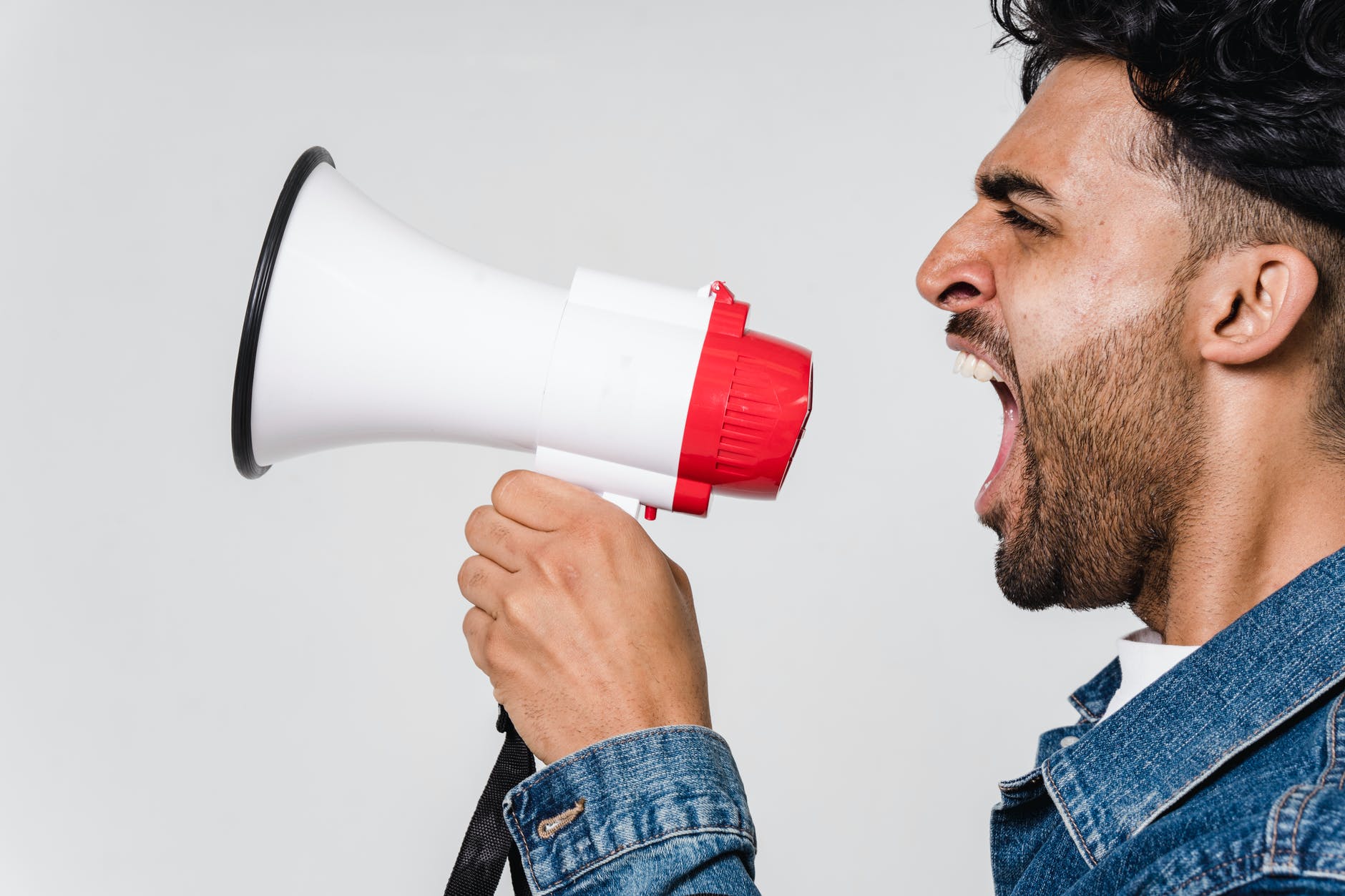 man in blue denim jacket holding a megaphone