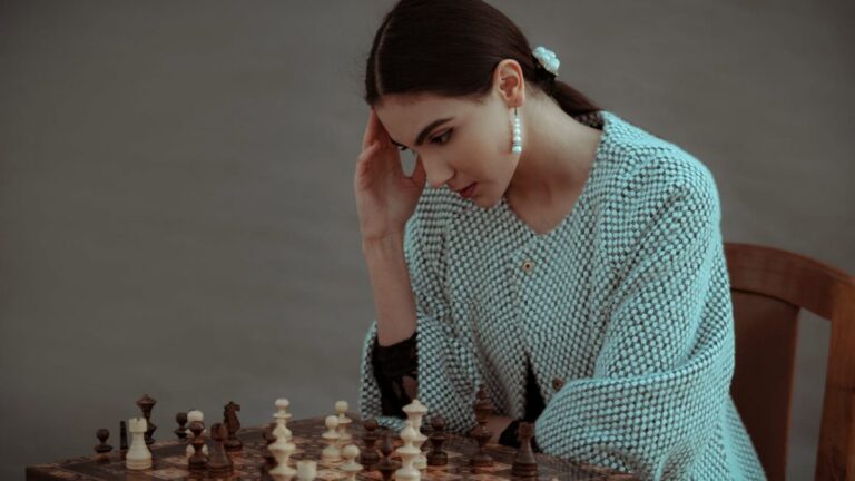 pensive ethnic woman thinking on chess move